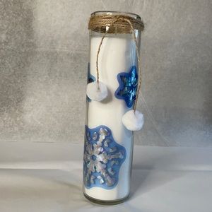 Candle white with snowflake details tied with brown twine and white puffballs